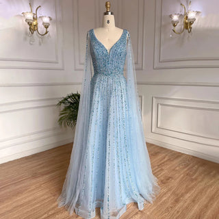 Desert Mirage: Dubai-Inspired Nude Evening Gown with Cape Sleeves Accented in Elegant Blue - A Vision of Grace for Weddings and Celebrations.
