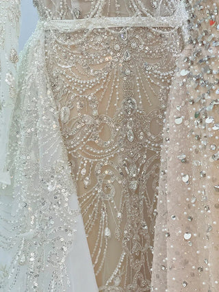 Desert Elegance: Dubai-Inspired White Nude Evening Gown with Overskirt and Feathers - A Beaded Bridal Luxury for Wedding Parties.