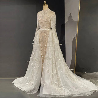 Desert Elegance: Dubai-Inspired White Nude Evening Gown with Overskirt and Feathers - A Beaded Bridal Luxury for Wedding Parties.